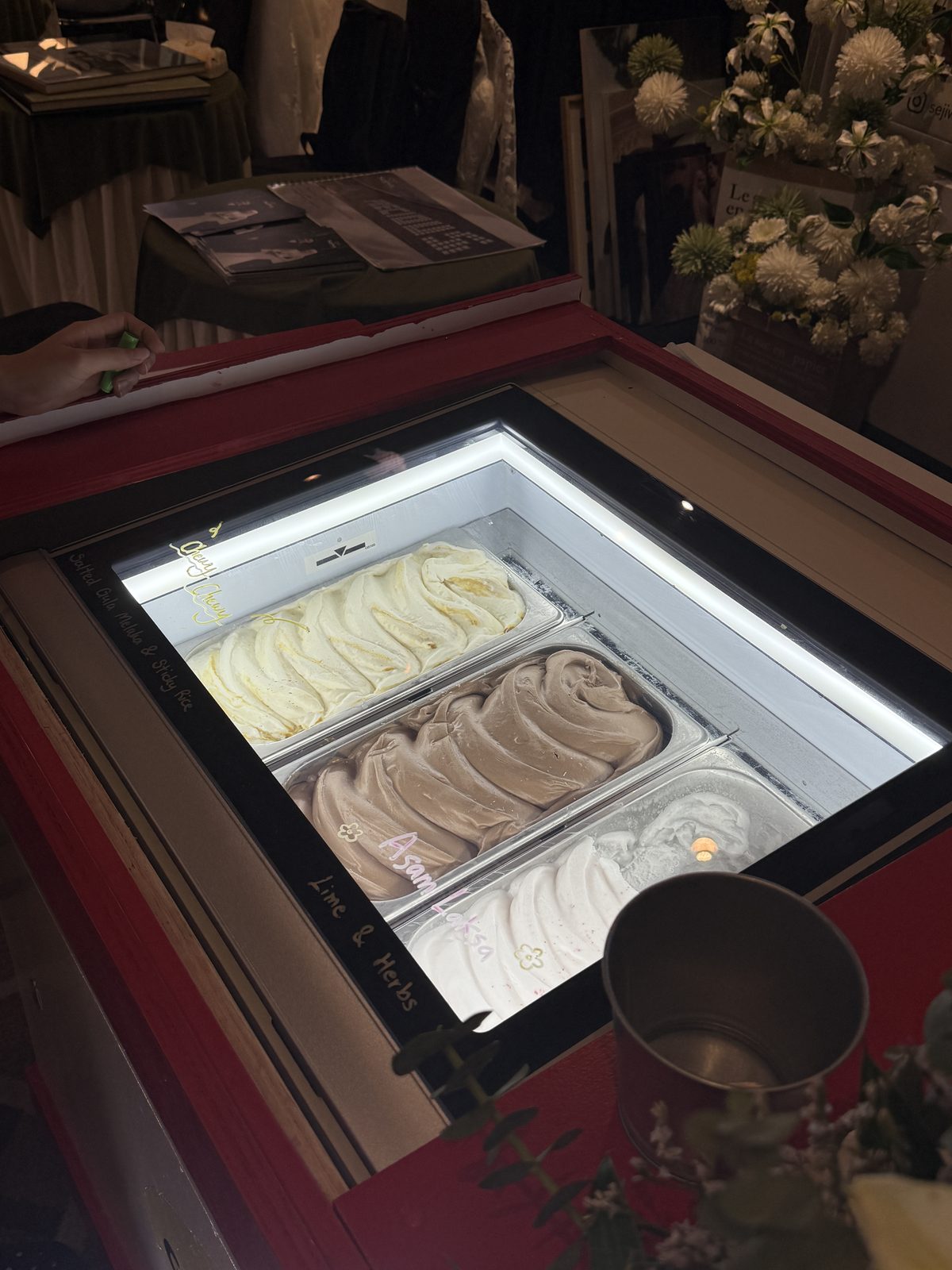Tubs of gelato in the lit displayer on the cart, ready to scoop
