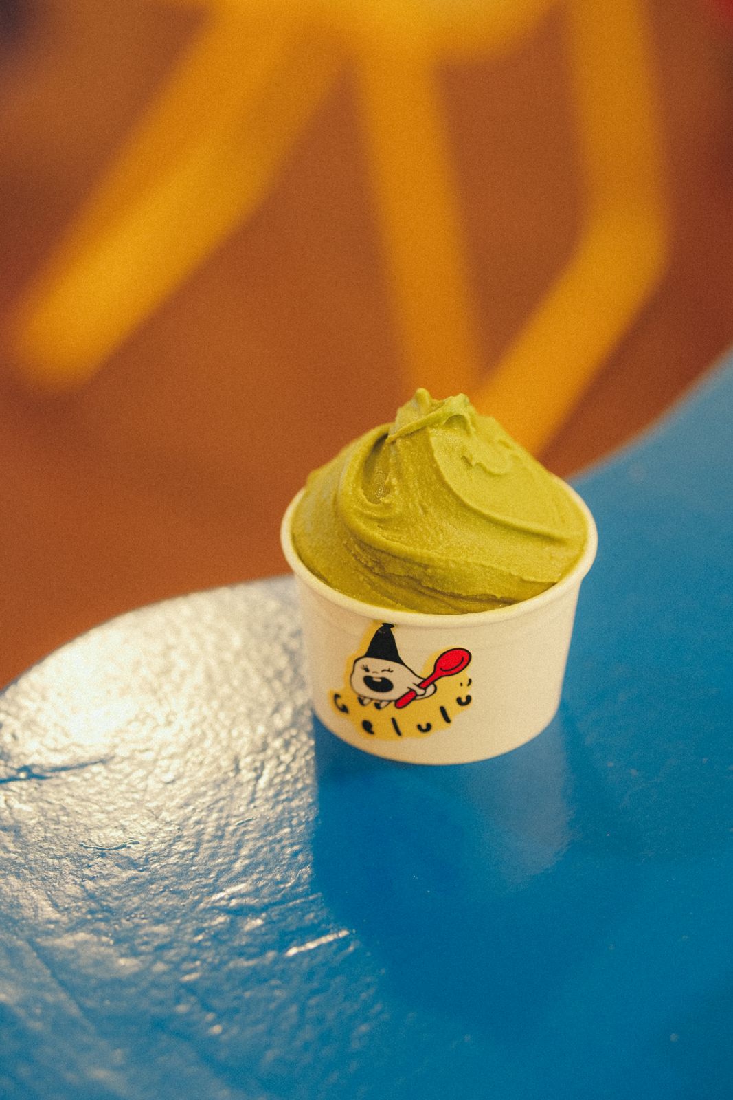 A cup of matcha gelato on the blue counter